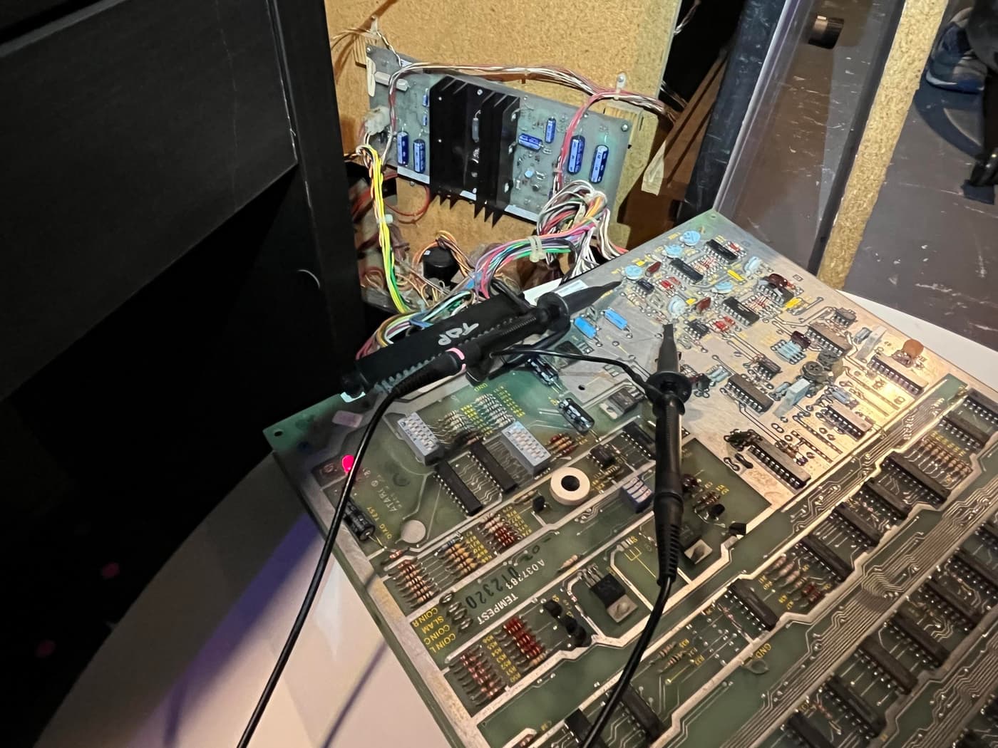 An open arcade cabinet with circuit board and wires