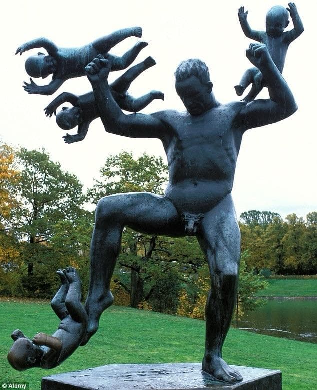 A bronze sculpture depicting a nude muscular man fighting and throwing several small figures resembling babies, set in a green park with trees and a body of water in the background.